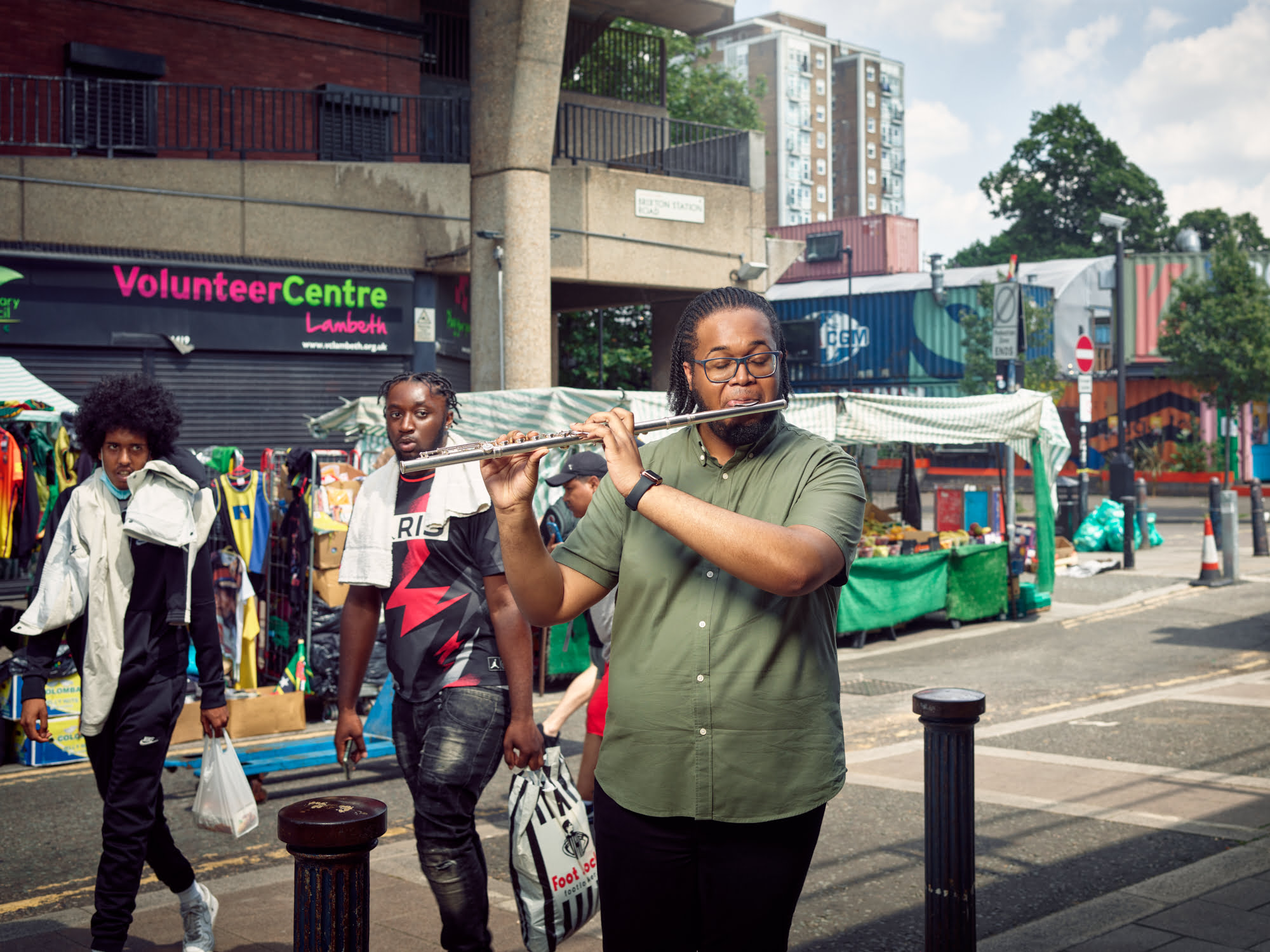 Deronne White, Brixton Station Road, outside The Rec Centre. A founding member of BCO, Deronne joined whilst still studying at Royal Academy of Music and says Brixton "always feels like home." We shot on Station Road opposite the listed-building 'Rec' leisure centre, regarded as one of the last areas possessing an authentic Brixton community feel. Despite the recent railway arches overhaul and the prospect of the â€˜Rec Quarter' redevelopment, the collection of cafes and shops occupying the railway arches, and daily market traders, together with locals shooting the breeze, still combine to give it a living identity.