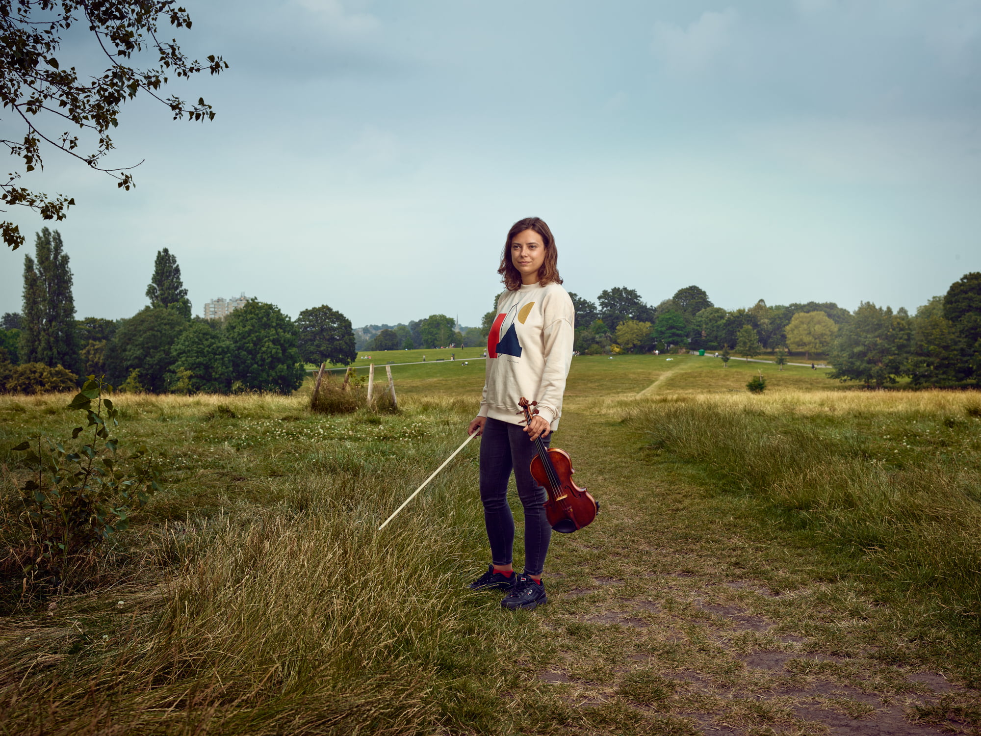 Jaga Klimaszewska, Brockwell Park, Hurst Street Estate in the distance. Originally from Gdansk, Poland, Jaga now performs worldwide after studying at Guildhall and Royal College of Music, but her London home is with BCO in Brixton, where the Victorian-era Brockwell Park in which she was photographed is now a cultural melting pot. Walk through the park on any given summer Sunday and you pass from Caribbean-flavoured BBQs to Central American cook ups to West African feasts, in the space of a few hundred metres.